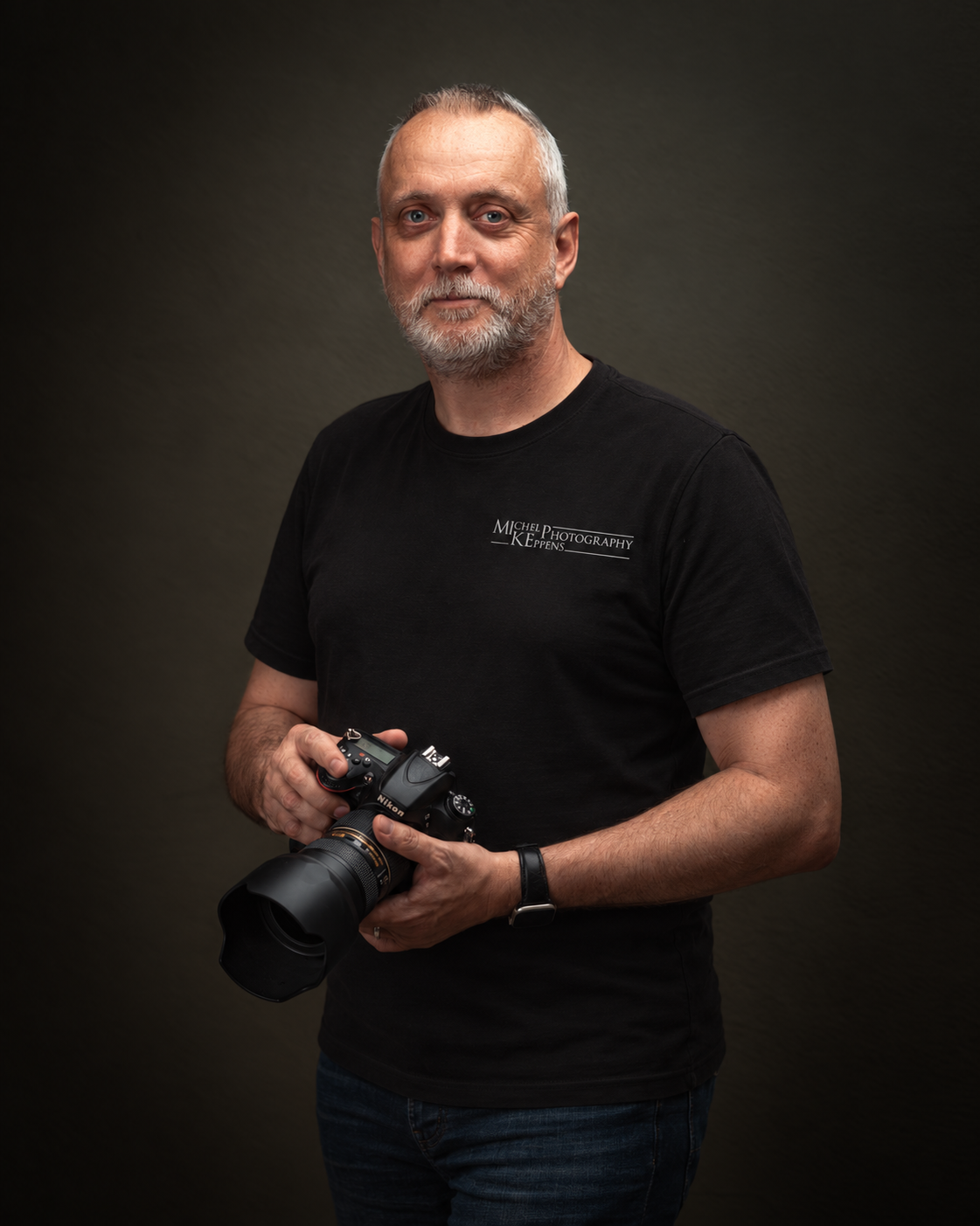 Michel Keppens met zijn camera, in een zwart T-shirt met logo